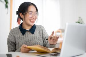 une intelligent, de bonne humeur Jeune asiatique femelle Université étudiant est en présentant sa projet via un en ligne réunion photo