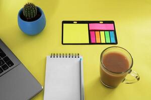 Vide carnet avec stylo sont sur Haut de bois Bureau bureau table avec une tasse de café et Bureau fournitures, Haut voir. photo