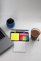 Vide carnet avec stylo sont sur Haut de bois Bureau bureau table avec une tasse de café et Bureau fournitures, Haut voir. photo