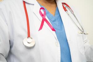cancer du sein, femme médecin asiatique avec ruban rose, symbole de la journée mondiale du cancer du sein. photo
