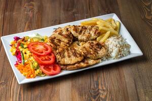 blanc assiette avec poulet, riz, et légumes photo