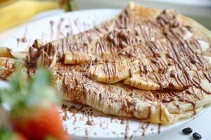 blanc assiette avec enrobé de chocolat banane tranches photo