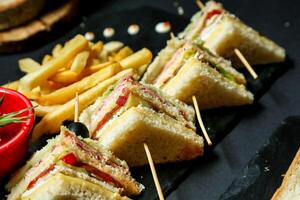 assiette de des sandwichs et français frites sur noir assiette photo