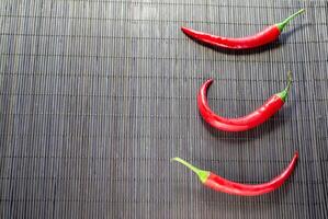 rouge chaud le Chili poivrons sur bambou serviette de table photo