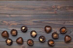 différent sortes de des chocolats sur coloré table fermer. Haut vue et plat allonger avec copie espace photo