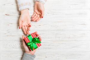 Haut vue de une homme et une femme féliciter chaque autre avec une cadeau sur en bois Contexte. surprise pour une vacances concept. copie espace photo