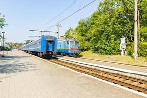 vieux bleu train est en quittant le plate-forme à le chemin de fer station photo