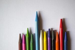 multicolore des crayons sur blanc Contexte. une palette de des crayons sur une tableau, proche en haut. photo