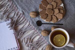 une tasse de thé avec citron et Gâteaux. hygge plat poser. photo