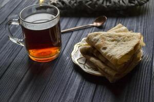 une tasse de thé et Gâteaux sur une rustique tableau. confortable hiver temps. photo