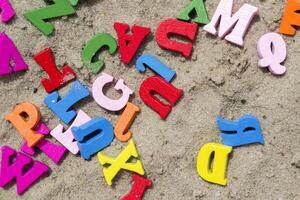 multicolore en bois des lettres sur une le sable proche en haut. photo