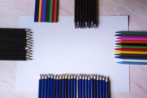 le ensemble de des crayons et blanc papier sur le tableau. photo