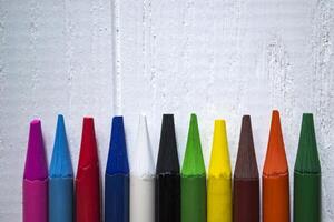 multicolore des crayons sur blanc Contexte. une palette de des crayons sur une tableau, proche en haut. photo