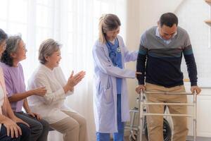 asiatique Jeune infirmière soutien Sénior plus âgée homme marcher avec marcheur. magnifique infirmière Aidez-moi et prendre se soucier. personnes âgées mature grand-père patient Faire physique thérapie avec une groupe de Sénior copains dans hôpital. photo