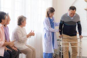 asiatique Jeune infirmière soutien Sénior plus âgée homme marcher avec marcheur. magnifique infirmière Aidez-moi et prendre se soucier. personnes âgées mature grand-père patient Faire physique thérapie avec une groupe de Sénior copains dans hôpital. photo