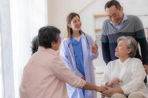 asiatique Jeune infirmière soutien couple Sénior plus âgée homme et femme dans une fauteuil roulant. personnes âgées mature et une groupe de Sénior copains vivant dans le hôpital. socialiser de retraité personnes. photo