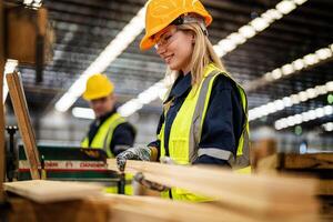 femme nettoyage Charpente bois dans foncé entrepôt industrie. équipe ouvrier Charpentier portant sécurité uniforme et difficile chapeau travail et vérification le qualité de en bois des produits à atelier fabrication. photo