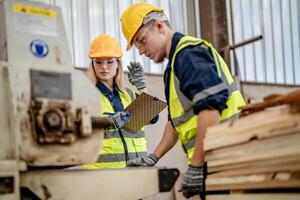 ouvrier charpentiers travail dans Machines à Couper bois Charpente. homme et femme sont artisanat avec bois dans une atelier. deux artisans ou bricoleurs travail avec Charpentier outils ou électrique Machines. photo