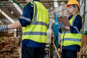 ouvrier charpentiers travail dans Machines à Couper bois Charpente. homme et femme sont artisanat avec bois dans une atelier. deux artisans ou bricoleurs travail avec Charpentier outils ou électrique Machines. photo