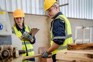 ouvrier charpentiers travail dans Machines à Couper bois Charpente. homme et femme sont artisanat avec bois dans une atelier. deux artisans ou bricoleurs travail avec Charpentier outils ou électrique Machines. photo