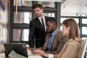 diverse des employés recueillies dans Bureau ayant amusement pendant réflexion tandis que discuter Nouveau des idées projet. multiracial collègues de travail réunion à cotravail espace zone. équipe de Jeune gens dans bureau. photo