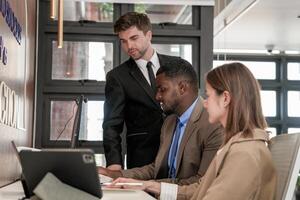 diverse des employés recueillies dans Bureau ayant amusement pendant réflexion tandis que discuter Nouveau des idées projet. multiracial collègues de travail réunion à cotravail espace zone. équipe de Jeune gens dans bureau. photo