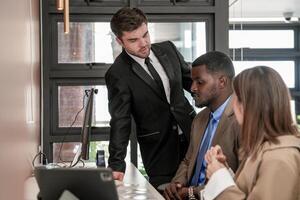 diverse des employés recueillies dans Bureau ayant amusement pendant réflexion tandis que discuter Nouveau des idées projet. multiracial collègues de travail réunion à cotravail espace zone. équipe de Jeune gens dans bureau. photo