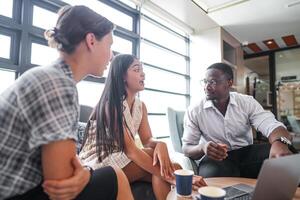 diverse des employés recueillies dans Bureau ayant amusement pendant réflexion tandis que discuter Nouveau des idées projet. multiracial collègues de travail réunion à cotravail espace zone. équipe de Jeune gens dans bureau. photo