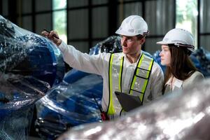 affaires ingénieurs rencontrer et vérifier contrôle lourd machine robot bras. diverse équipe de industriel la robotique ingénieurs recueillies autour machine. professionnel machinerie opérateur utilisation industriel numérique tablette. photo