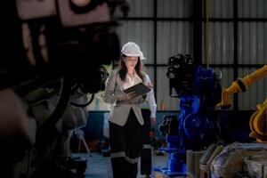 affaires femme et homme réunion et vérification Nouveau machine robot. ingénieur en marchant à entrepôt industrie machine. affaires négociation concepts et technologie. femme est en utilisant intelligent tablette à présent homme. photo