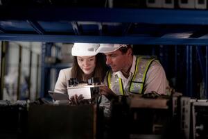 technicien ingénieurs équipe vérification le machine et entretien service. ouvriers à la recherche à de rechange les pièces dans Stock à entrepôt usine. ouvrier avec une liste de contrôle à la recherche sur partie de machine les pièces. photo