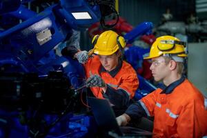 affaires ingénieurs rencontrer et vérifier contrôle lourd machine robot bras. diverse équipe de industriel la robotique ingénieurs recueillies autour machine. professionnel machinerie opérateur utilisation industriel numérique tablette. photo