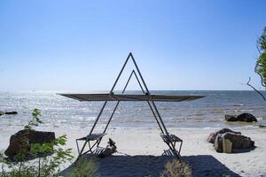 une tonnelle avec bancs sur le plage. magnifique paysage marin. le endroit pour repos. photo