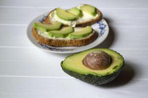 tranché Avocat. en bonne santé aliments. savoureux végétalien petit déjeuner. photo