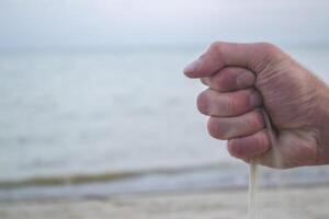 le le sable est verser de Masculin mains. photo