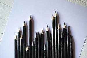 le ensemble de gris des crayons sur une blanc Contexte. outils pour dessin sur le bureau. photo