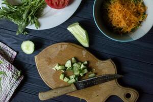 tranché concombre sur le planche avec autre Ingrédients pour cuisson. photo