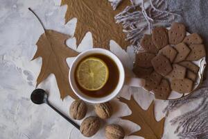 une tasse de thé avec citron et Gâteaux. hygge plat poser. photo