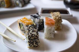 ensemble de Sushi Rouleaux avec vasabi et gingembre sur une blanc plaque. photo