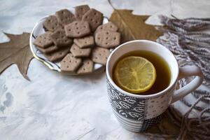 une tasse de thé avec citron et Gâteaux. hygge plat poser. photo