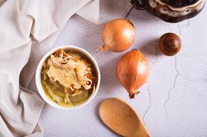 fait maison oignon soupe avec Croûtons et fromage dans une bol sur le table Haut vue photo