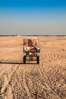 bédouins de premier plan touristes sur chameaux à court touristique tour autour le début donc appelé des portes de Sahara désert photo