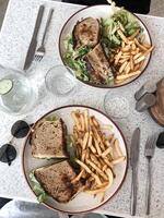 des sandwichs avec fromage, laitue, tomate et français frites dans une restaurant photo