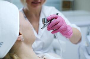professionnel cosmétologue performant aérographe soin de la peau traitement photo