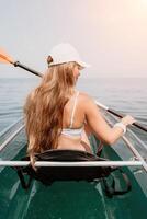 femme dans kayak retour voir. content Jeune femme avec longue cheveux flottant dans transparent kayak sur le cristal clair mer. été vacances vacances et de bonne humeur femelle gens relaxant ayant amusement sur le bateau photo