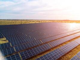 aérien Haut vue de une solaire panneaux Puissance plante. photovoltaïque solaire panneaux à lever du soleil et le coucher du soleil dans campagne de au-dessus de. moderne technologie, climat se soucier, Terre économie, renouvelable énergie concept. photo