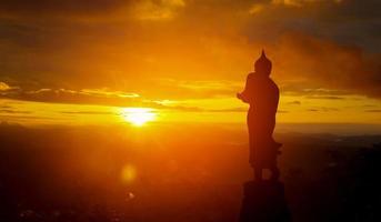 statue de bouddha silhouette sur fond de coucher de soleil photo