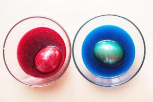 de fête peint Pâques des œufs avec coloré colorants sur le table à maison. photo