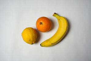 orange, citron et banane sur blanc Contexte. photo