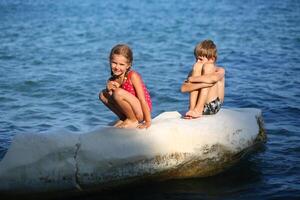 les enfants bain de soleil sur le Roche sur le Chypre rivage photo